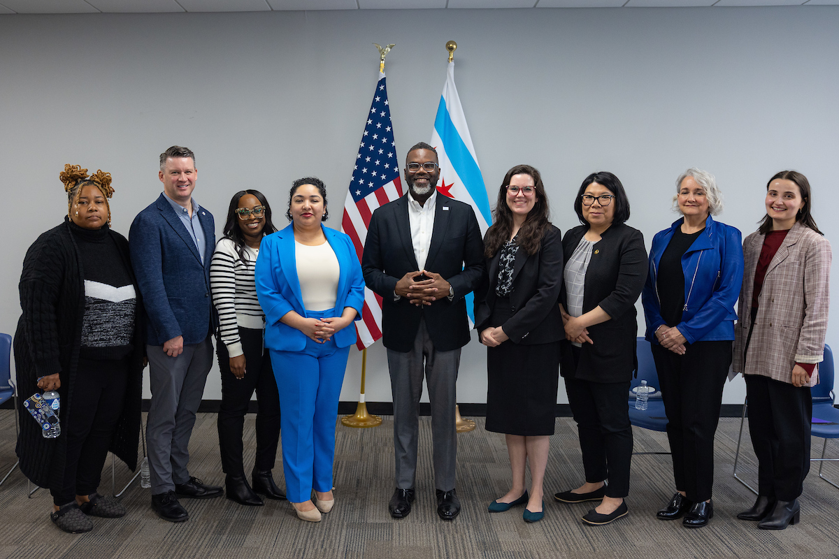 Image of Mayor Johnson in the center, surrounded by Non-profit advocates, Alder people, and staff at press conference. 